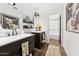 Well-lit bathroom includes dual sink vanities and wood floors with a doorway to a bathroom with a tub at 9801 W Rockwood Dr, Peoria, AZ 85382