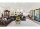 Open-concept living room with vaulted ceilings, a large leather sectional, and bright, neutral decor at 9801 W Rockwood Dr, Peoria, AZ 85382