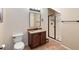 Well-lit bathroom featuring a vanity with granite countertop, a toilet, and a glass-enclosed shower at 11048 E Quintana Ave, Mesa, AZ 85212