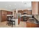 Well-equipped kitchen featuring dark wood cabinets, granite countertops, and stainless steel appliances for the home chef at 11048 E Quintana Ave, Mesa, AZ 85212