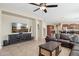 Spacious living room showcasing a large TV, comfortable seating, and an open layout leading to the kitchen at 11048 E Quintana Ave, Mesa, AZ 85212