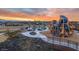 Community playground area at sunset featuring modern climbing structures, slides, and shaded picnic tables at 11048 E Quintana Ave, Mesa, AZ 85212