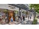 Exterior view of inviting retail shops with pedestrian traffic and appealing storefronts under a modern trellis at 11048 E Quintana Ave, Mesa, AZ 85212