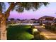Landscaped backyard with a gazebo, lighted pathways, lush lawn, and mature trees, creating a serene retreat at 11601 N 64Th Pl, Scottsdale, AZ 85254