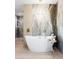Luxurious bathroom with a modern soaking tub, stylish fixtures, and an elegant accent wall at 11601 N 64Th Pl, Scottsdale, AZ 85254