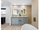 Bright bathroom features stylish vanity with illuminated mirror and wood-look tile at 11601 N 64Th Pl, Scottsdale, AZ 85254