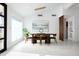 Modern dining room with an elegant light fixture, sleek table, and a picturesque window view at 11601 N 64Th Pl, Scottsdale, AZ 85254