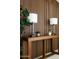 Stylish entryway features a wooden console table with lamps against a wood-paneled accent wall at 11601 N 64Th Pl, Scottsdale, AZ 85254