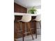 Kitchen island with white countertop and wood accent, paired with stylish beige upholstered stools at 11601 N 64Th Pl, Scottsdale, AZ 85254