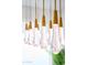 Close-up of a modern pendant lighting fixture with raindrop-shaped glass and brass accents at 11601 N 64Th Pl, Scottsdale, AZ 85254