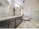 Bright bathroom with double vanity, tiled floor, soaking tub, and glass shower at 1217 S Longmore Ct, Chandler, AZ 85286