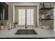 Well-lit kitchen sink area featuring white countertops, floating shelves, and modern fixtures at 1217 S Longmore Ct, Chandler, AZ 85286