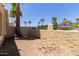 Backyard with palm trees, a brick fire pit, and an iron fence at 1235 N Sunnyvale -- # 113, Mesa, AZ 85205