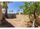 Desert backyard featuring a brick fire pit, trees, and an iron fence, creating a peaceful outdoor retreat at 1235 N Sunnyvale -- # 113, Mesa, AZ 85205