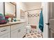 Well-lit bathroom with vanity, granite countertop, decorative mirrors, and patterned tile floors at 1235 N Sunnyvale -- # 113, Mesa, AZ 85205