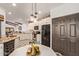 Bright kitchen featuring white cabinets, black appliances, and adjacent dining area with pendant lighting at 1235 N Sunnyvale -- # 113, Mesa, AZ 85205