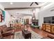 Open-concept living room with a comfortable leather sectional, a fireplace, and open access to the kitchen at 1235 N Sunnyvale -- # 113, Mesa, AZ 85205