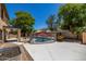 Fenced backyard featuring a private pool, lush landscaping, and an outdoor kitchen area at 14129 W St Moritz Ln, Surprise, AZ 85379