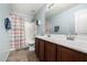Bathroom featuring double sinks, wooden cabinets, shower, and tiled floor at 14129 W St Moritz Ln, Surprise, AZ 85379