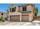 Side view of a two-story stucco home featuring a tiled roof and a two-car garage, all in a well-maintained neighborhood at 14129 W St Moritz Ln, Surprise, AZ 85379