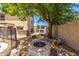 Backyard featuring an outdoor fire pit area with stone seating and lush landscaping at 14129 W St Moritz Ln, Surprise, AZ 85379