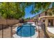 Backyard view of the sparkling blue pool area enclosed by a fence, set among desert landscaping at 14129 W St Moritz Ln, Surprise, AZ 85379