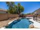 Landscaped backyard featuring a swimming pool with a rock waterfall, and mature trees at 14129 W St Moritz Ln, Surprise, AZ 85379