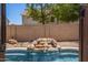 The pool has a custom rock waterfall feature, adding a tranquil ambiance to the outdoor space at 14129 W St Moritz Ln, Surprise, AZ 85379