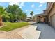 Expansive backyard featuring lush artificial grass, patio, lounge area, and an outdoor kitchen space at 14364 W Cameron Dr, Surprise, AZ 85379