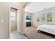 Inviting bedroom with natural light, mounted television, and attached tiled closet and doorway at 14364 W Cameron Dr, Surprise, AZ 85379