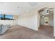 Open living room space with large wall-mounted TV and plush carpet flooring throughout at 14364 W Cameron Dr, Surprise, AZ 85379