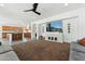 Spacious open concept living room boasts plush carpeting, ceiling fan, and open view of the kitchen at 14364 W Cameron Dr, Surprise, AZ 85379