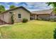 Spacious backyard with lush green lawn, mature landscaping, and a cozy patio area at 17765 W Ventura St, Surprise, AZ 85388