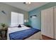 Cozy bedroom with a blue accent wall, a plush bed, and natural light from a window at 17765 W Ventura St, Surprise, AZ 85388