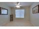 A bright bedroom with tile flooring, a ceiling fan, and a large window with lace curtains at 17765 W Ventura St, Surprise, AZ 85388