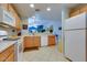 Open kitchen with white appliances and wooden cabinetry, offering an inviting view to another room at 17765 W Ventura St, Surprise, AZ 85388