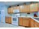 Bright kitchen features wooden cabinetry, white appliances, and neutral countertops at 17765 W Ventura St, Surprise, AZ 85388