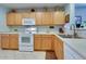 Functional kitchen with wood cabinetry, white appliances, and a practical layout for everyday use at 17765 W Ventura St, Surprise, AZ 85388