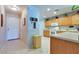 Kitchen view with neutral countertops, wooden cabinets, and tile floors leading to the entrance at 17765 W Ventura St, Surprise, AZ 85388