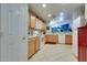 Well-lit kitchen featuring white appliances, wood cabinets, and a glimpse into an adjacent room at 17765 W Ventura St, Surprise, AZ 85388