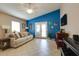 Bright living room with a blue accent wall, French doors, and ample space for entertaining at 17765 W Ventura St, Surprise, AZ 85388
