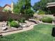 Backyard with a rock and green shrub bed, trees, and green lawn at 1819 E Sheena Dr, Phoenix, AZ 85022