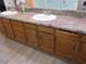 Bathroom featuring double sinks with granite countertop and wood cabinets, with tile flooring at 1819 E Sheena Dr, Phoenix, AZ 85022