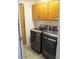A well-lit laundry room equipped with modern washer, dryer and ample cabinet storage at 1819 E Sheena Dr, Phoenix, AZ 85022