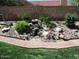 Landscaped rock water feature with mature plants adding natural beauty to the outdoor space at 1819 E Sheena Dr, Phoenix, AZ 85022
