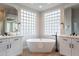 Bright bathroom featuring a freestanding tub, double vanity, and modern fixtures at 19608 N Regents Park Dr, Surprise, AZ 85387