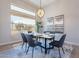 Elegant dining area with modern chandelier, dining set, and a large window view at 19608 N Regents Park Dr, Surprise, AZ 85387