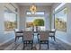 Modern dining room with a stylish table setting, unique chandelier, and plenty of natural light at 19608 N Regents Park Dr, Surprise, AZ 85387