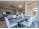 Open-concept dining area with contemporary furnishings, pendant lighting, and seamless flow to living spaces at 19608 N Regents Park Dr, Surprise, AZ 85387