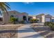 Charming home with landscaped front yard, mature palm trees, and a walkway to the front door at 19608 N Regents Park Dr, Surprise, AZ 85387